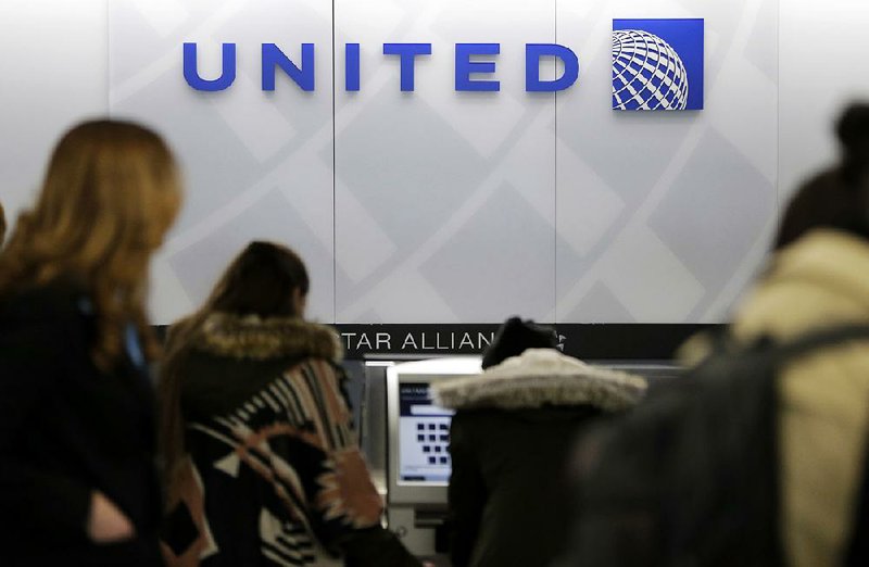 United Airlines customers wait in line at the airline’s counter at LaGuardia Airport in New York in March. The airline said Thursday it is raising the limit on payments to customers who give up seats on oversold flights to $10,000.

