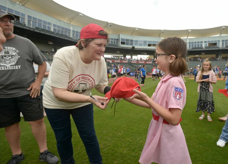 Megan Cavanagh, who played Marla Hooch in “A League of Their Own,” autographs a hat at last year’s reunion softball game. Guests are invited to come dressed in superhero garb to this year’s game at 11 a.m. May 7 at Arvest Ballpark in Springdale as festival organizers attempt to break the Guinness World Record for most people wearing superhero costumes assembled in an enclosed area. Admission is $6.