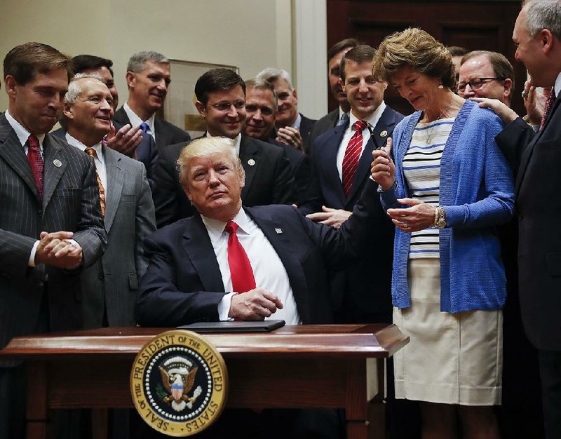 After signing an executive order directing a review of restrictive policies on offshore drilling, President Donald Trump hands the pen he used to Sen. Lisa Murkowski, R-Alaska, on Friday at the White House.