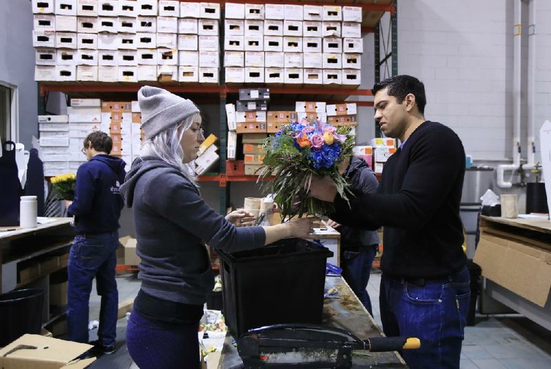 Ajay Kori (right) owner of UrbanStems, and Megan Sanders prepare fresh flowers for delivery last week at the company’s warehouse, in Washington. 
