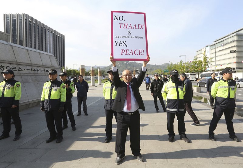 A South Korean protester holds up a placard opposing a plan to deploy the advanced U.S. missile defense system called Terminal High-Altitude Area Defense, or THAAD, near U.S. Embassy in Seoul, South Korea, Thursday, April 27, 2017. 