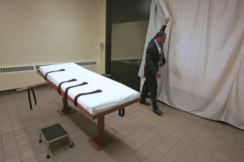 In this November 2005 file photo, Larry Greene, public information director of the Southern Ohio Correctional Facility, demonstrates how a curtain is pulled between the death chamber and witness room at the prison in Lucasville, Ohio.