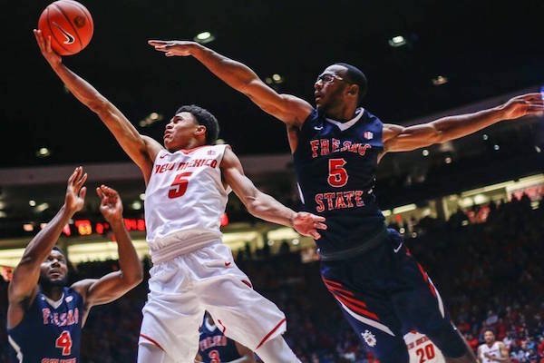 Fresno State forward Karachi Edo (4) and guard Jahmel Taylor contest a drive to the basket by New Mexico guard Jalen Harris in the second half of the Lobos’ 78-73 victory.  JUAN ANTONIO LABRECHE Associated Press
