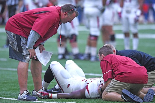 Arkansas head coach Bret Bielema watches as support personnel assist Rawleigh Williams III Saturday April 29, 2017 after he was injured on a play during a red-white scrimmage. Williams left the practice in am ambulance. 