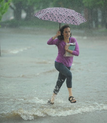 Ashley Harrington of Fayetteville runs Saturday, April 29, 2017, through high water across Dickson Street at West Avenue in Fayetteville as heavy rains fall.