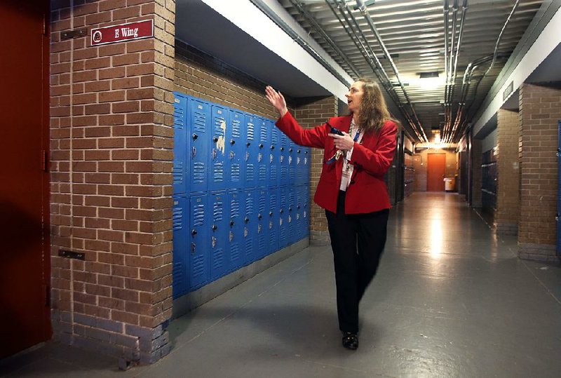 Emma Nowden, vice principal at McClellan High School, points out a damaged brick wall in a hallway at the school. The Little Rock School District says a millage extension would provide money for a new classroom building at McClellan.