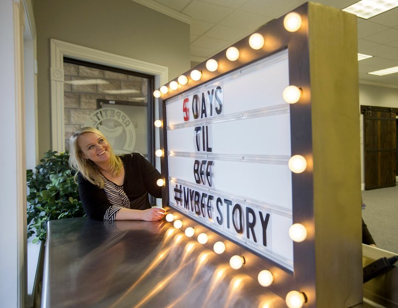 Elisha Alas, office manager, helps set up a marquee Friday for the Bentonville Film Festival at Elkins Design in downtown Bentonville. The festival begins Tuesday.