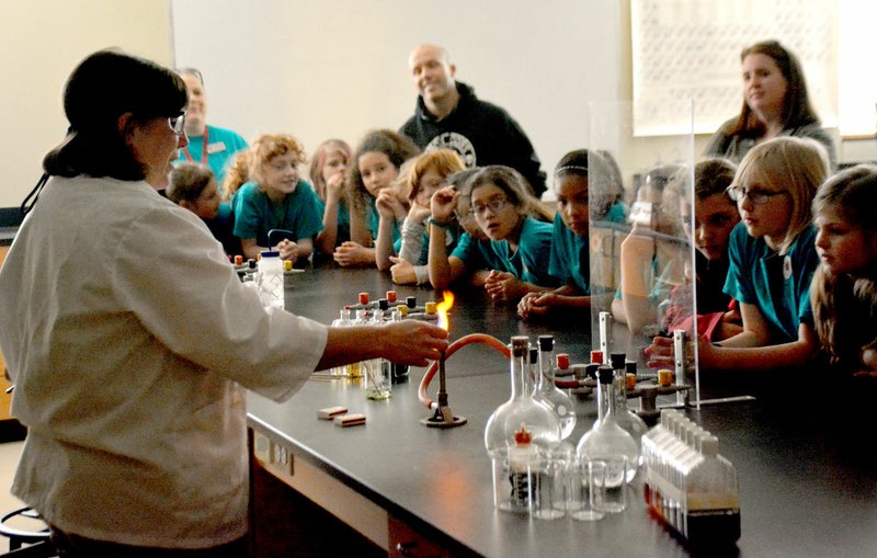 Janelle Jessen/Herald-Leader Susan Newton, a chemistry professor at John Brown University, demonstrated the way different elements create different colored flames when they burn to fourth-grade students.