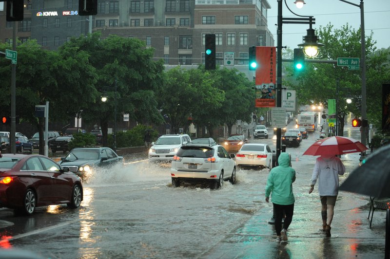 Traffic passes through high water across Dickson Street at West Avenue in Fayetteville after heavy rain caused torrential flooding in April 2017. The event prompted city officials find ways to pay for drainage projects, including more than $15 million included in a bond referendum.