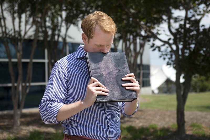 In this Wednesday, Aug. 26, 2015, file photo, WDBJ news anchor Chris Hurst pauses as he is overcome with emotion while holding a photo album that was created by fellow reporter and girlfriend Alison Parker, in Roanoke, Va. Hurst was living with Alison Parker when she and cameraman Adam Ward were fatally shot by a former co-worker while reporting for WDBJ-TV in August 2015. Hurst said he's seeking a Virginia state House seat to give back to the community that helped him through his darkest days. 