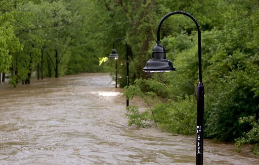 The top of light posts are visible Wednesday, April 26, 2017, after heavy rains caused flooding by the Town Branch Creek near South School Avenue in Fayetteville. Heavy rains caused flooding and submerged portions of the Razorback Regional Greenway Trail including portions of the Town Branch section.