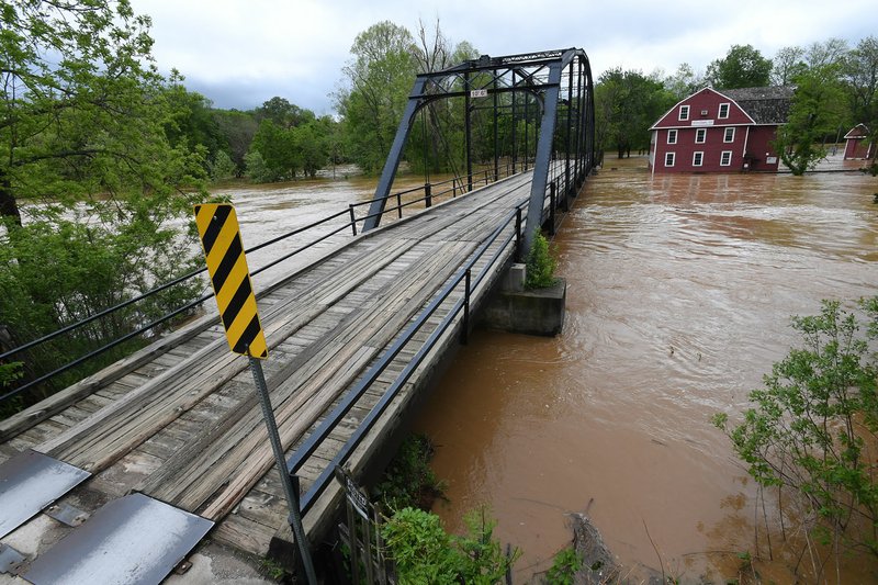 The War Eagle Mill stands in floodwater Sunday. Benton County officials say the historic War Eagle Bridge will be closed for repair beginning the week of May 8 and remain closed until the work is done later this year.