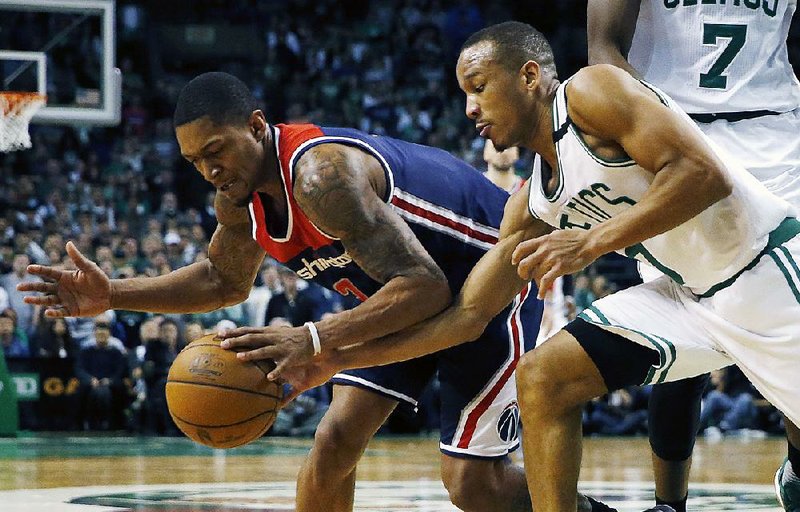 Boston’s Avery Bradley (right) knocks the ball away from Washington’s Bradley Beal during the fourth quarter of Sunday’s game. The top-seeded Celtics got off to a slow start but rebounded to put away the Wizards 123-111 in the opener of their NBA Eastern Conference semifi nal playoff series.