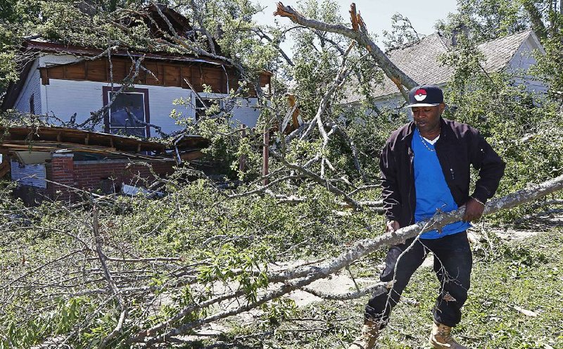 Dee Andre Johnson, 48, hauls off branches Monday that fell on his neighbor’s house Sunday morning during a possible tornado that swept through Durant, Miss.