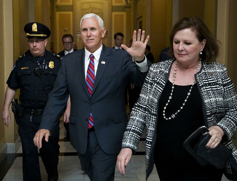 Vice President Mike Pence walks past reporters in a U.S. Capitol hallway Monday in Washington.