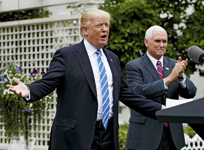 Vice President Mike Pence applauds Monday as President Donald Trump arrives in the Kennedy Garden of the White House in Washington to speak to the Independent Community Bankers Association.
