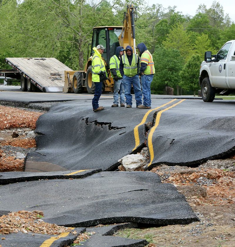 Washington County Road Department personnel survey damage Monday on County Road 859 in Wheeler. Heavy rains caused flooding on area creeks, including Clear Creek.