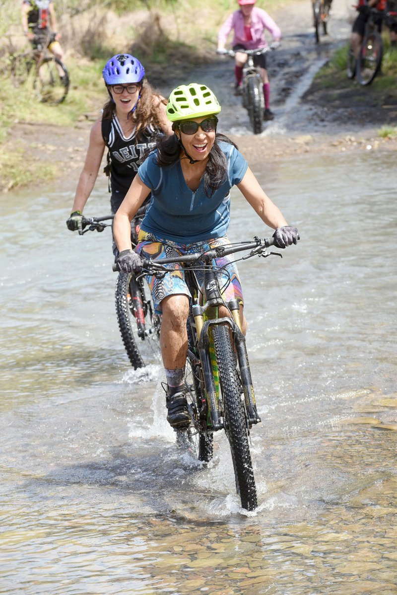 Adriana Perez Chavarria of Bella Vista pedals across Lee Creek at the 29th annual Ozark Mountain Bike Festival at Devil's Den State Park near Winslow. The festival features guided mountain bike rides, cycling games, a mountain bike poker run and a Saturday evening cookout for riders.
