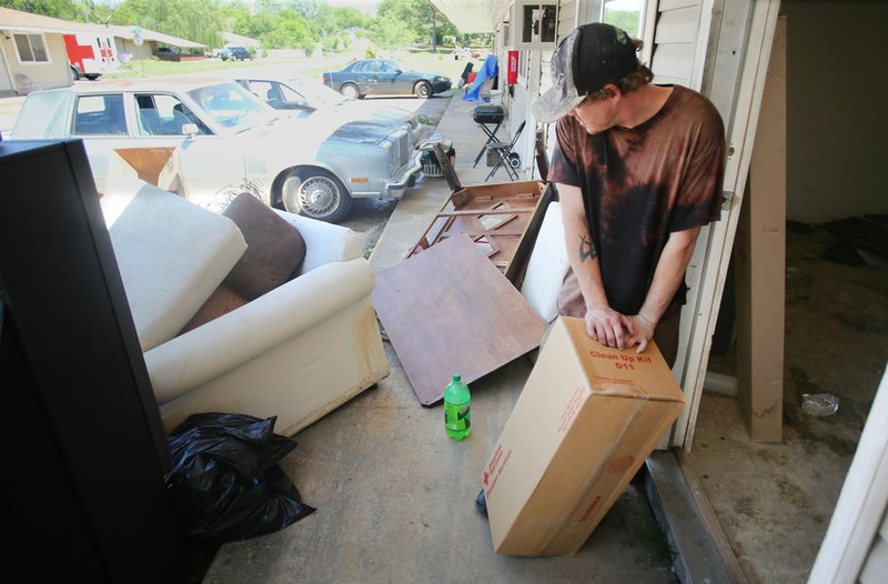 NWA Democrat-Gazette/DAVID GOTTSCHALK Tini Kratchmer (left), a volunteer with the American Red Cross&#8217; Northwest Arkansas chapter, collects information Tuesday from Sandy Crihfield on her front porch at West End Apartments in Fayetteville. Rain and a swollen creek caused flooding at the complex, causing extensive water damage in the apartments and to personal property.