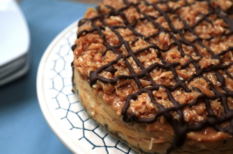 Pressure Cooker Samoa Cheesecake is topped with shredded coconut, caramel and chocolate. 