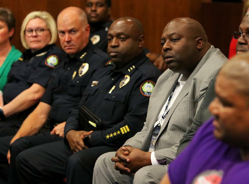 Little Rock Police Chief Kenton Buckner (in suit) and members of his staff listen Tuesday night.