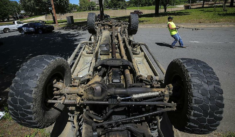 5/2/17
Arkansas Democrat-Gazette/STEPHEN B. THORNTON
Ray Cobb, with Metro Towing and Recovery, pulls as cable as he prepares to right an overturned pickup after a two vehicle accident Tuesday at 12th and Cumberland Streets in Little Rock. No injuries were reported.