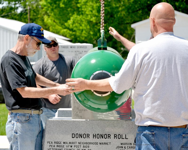 TIMES photograph by Annette Beard Submarine veteran Mike Rainwater, left, measures for correct placement of the Mark 37 torpedo in the memorial to submarine veterans at the Pea Ridge Veterans Memorial Tuesday, April 25. Rainwater was the project chief for the project and was assisted by Bob Andregg, project engineer, and Ken Spencer, also submarine veterans.