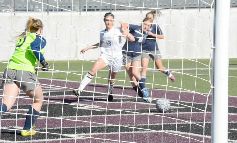 Graham Thomas/Herald-Leader Siloam Springs junior Brooklyn Buckminster fights off Greenwood&#8217;s Courtney Meyers as Lady Bulldogs goalkeeper Carley Zirbel charges in during the first half Monday.