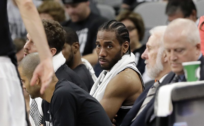 San Antonio Spurs forward Kawhi Leonard, center, sits on the bench during the second half in a second-round NBA playoff series basketball game against the Houston Rockets, Monday, May 1, 2017, in San Antonio. (AP Photo/Eric Gay)