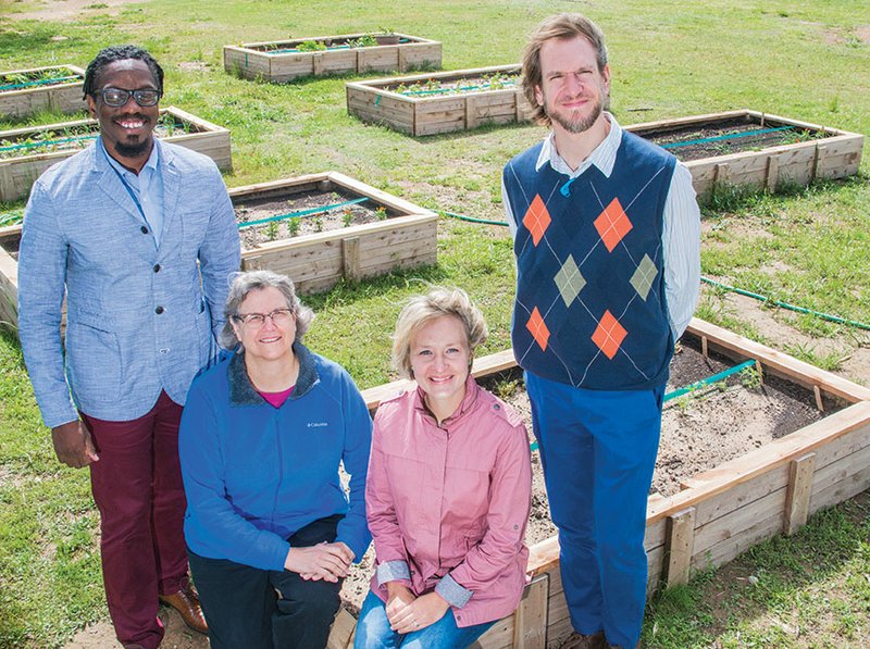 From left, Phillip Fletcher, Peg Falls-Corbitt, Jill Steed and the Rev. Mike Ulasewich stand in front of one of the raised garden beds at First Presbyterian Church in Conway. The community garden is a partnership between City of Hope Outreach, of which Fletcher is the founder, and the church.
