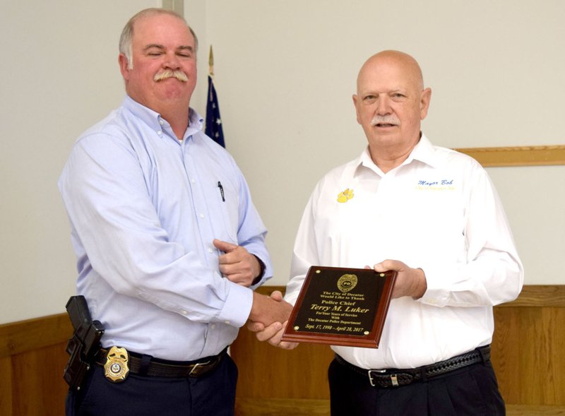 Decatur Police Chief Terry Luker received a plaque from Decatur Mayor Bob Tharp during his retirement reception April 28 in the community room at Decatur City Hall.