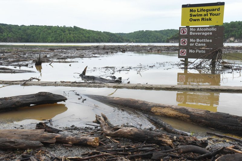 NWA Democrat-Gazette/FLIP PUTTHOFF Logs and debris clog the swim beach Wednesday at Horseshoe Bend park on Beaver Lake near Rogers. Lake officials said boaters should use caution, particularly on the south end of the lake, because of floating debris. The lake rose several feet after several rounds of rain.