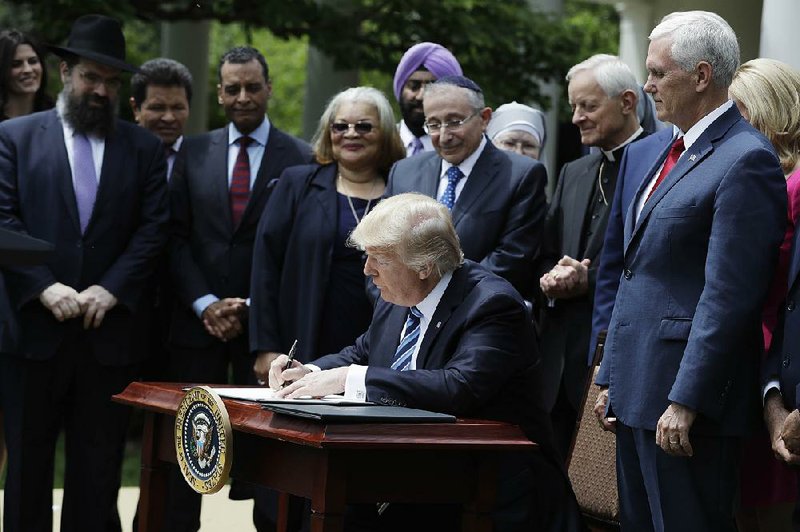 President Donald Trump signs an executive order Thursday that removes the financial threat that tax-exempt churches face from the Internal Revenue Service when pastors speak out on behalf of political candidates.

