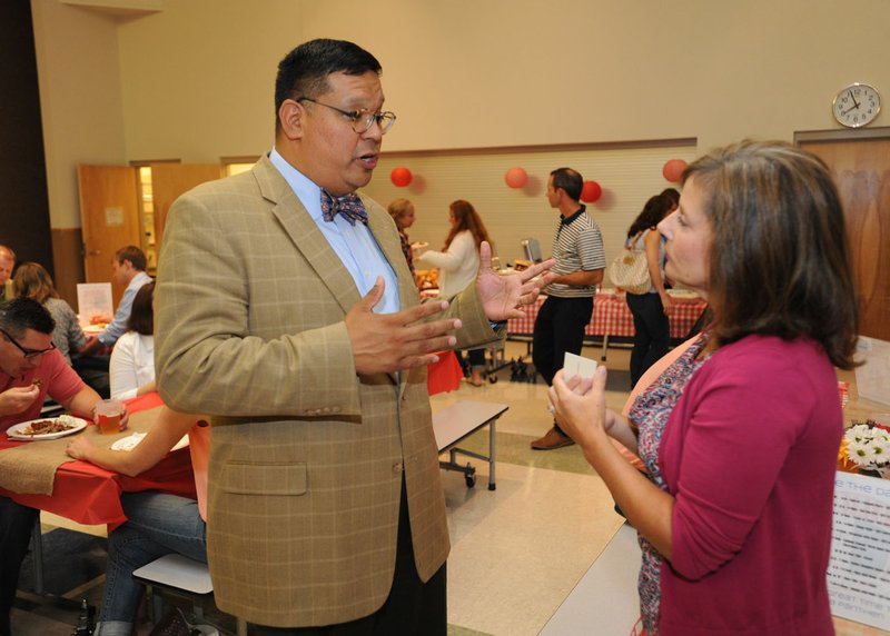 File Photo John Rocha Sr., head of school for the planned Ozark Catholic Academy, talks with Laurie Brady of Fayetteville in August while meeting with families at St. Joseph Catholic School in Fayetteville.