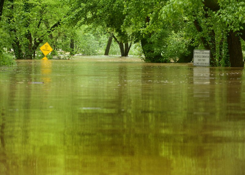 NWA Democrat-Gazette/BEN GOFF @NWABENGOFF Water crests over War Eagle Road Sunday near War Eagle Mill in Benton County East of Rogers.