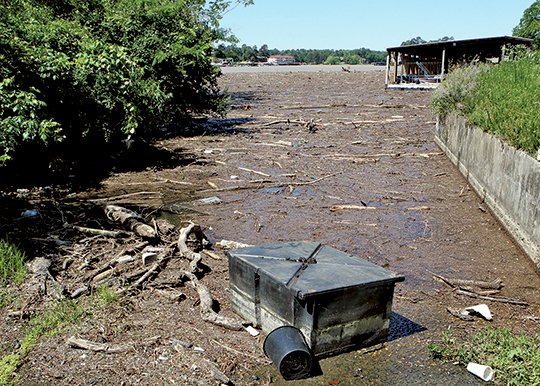 The Sentinel-Record/Richard Rasmussen LAKE DEBRIS: Debris washed into Lake Hamilton by overnight storms filled a cove near the Airport Road bridge on Monday. The U.S. Coast Guard Auxiliary is urging boaters to be cautious on area lakes due to floating debris.