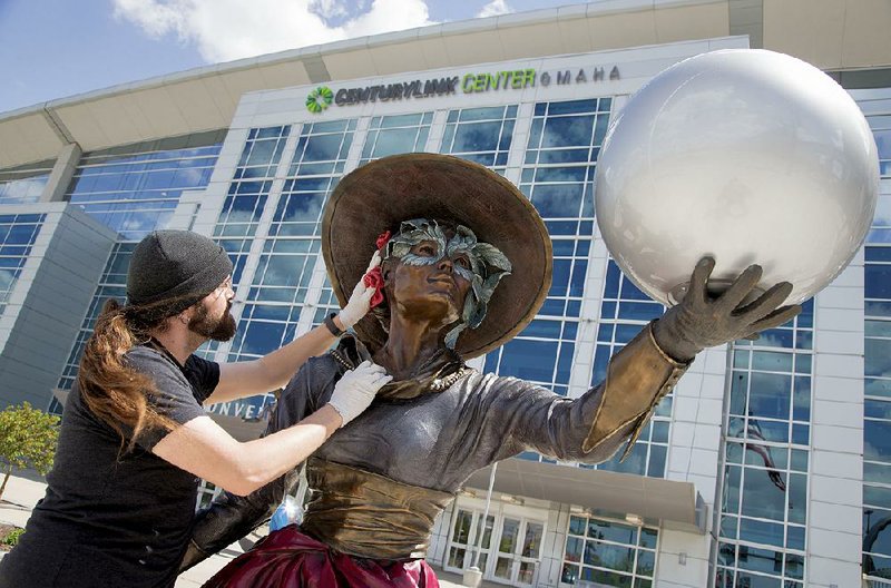 Ian Bless polishes a statue in front of the CenturyLink Center in Omaha, Neb., on Thursday in preparation for Berkshire Hathaway’s annual shareholders meeting today. 