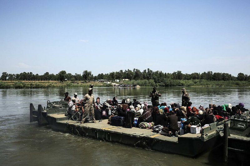 Iraqi civilians from western Mosul, where U.S.-backed forces are battling Islamic State militants, wait Friday for their ferry to cross the Tigris River to the liberated eastern part of the city. 