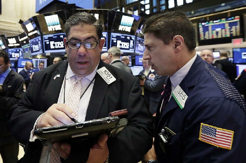 Traders Robert Oswald (left) and Anthony Carannante work Friday on the floor of the New York Stock Exchange where stocks rose after the government’s April jobs report was released. 