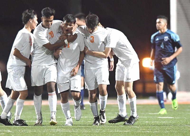 NWA Democrat-Gazette/J.T. WAMPLER Rogers Heritage players congratulate David Villanueva (11) on his first of two goals Friday against Springdale Har-Ber at Heritage.