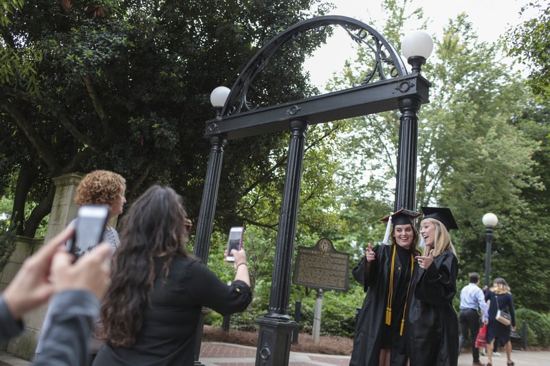 Soon-to-be graduates, Callie Rittweger, left, and Ashley Owen, right, from the University of Georgia's Franklin College of Arts communications program, pose for photos at the Arch, Thursday, May 04, 2017. 