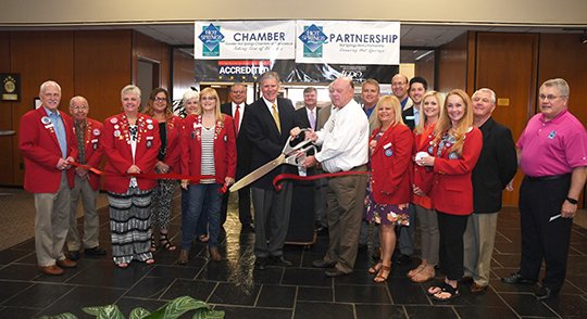 The Sentinel-Record/Mara Kuhn CELEBRATION: Hot Springs Mayor Pat McCabe, left, and County Judge Rick Davis, along with members of the Hot Springs Metro Partnership and The Greater Hot Springs Chamber of Commerce and its Ambassadors, cut a ceremonial ribbon for the start of Economic Development Week on Friday.