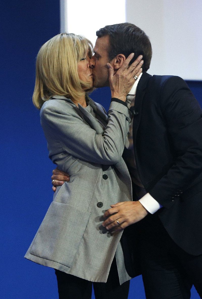 Emmanuel Macron’s wife, Brigitte, gives him a kiss at his headquarters in Paris on April 23. 