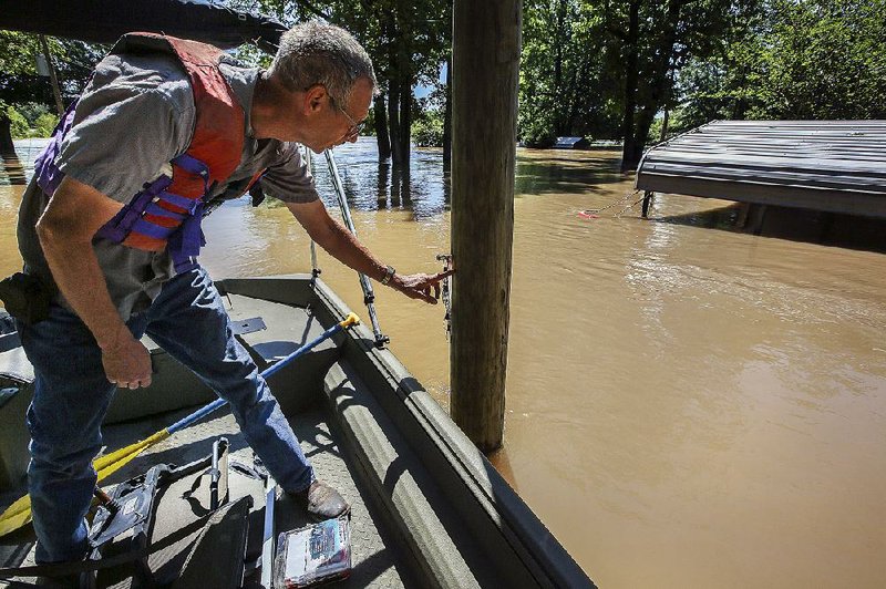Jerry Allen of Pleasant Plains points to a mark on a post in front of his cabin on the White River just north of Augusta, showing how high the water rose during 2011 flooding. The peg above his finger marks the highest the water has been in the past 100 years, Allen said. 