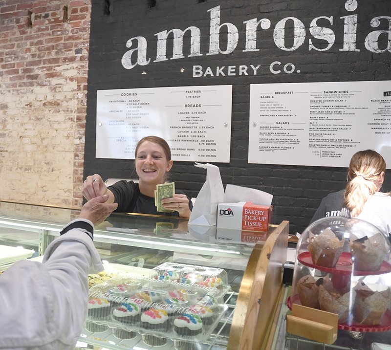 The Sentinel-Record/Mara Kuhn NEW LOCATION: Jewell Waltman with Ambrosia Bakery Co. sells baked goods Friday at the bakery's new downtown location at 307 Broadway St. The bakery has expanded to offer more breakfast items, light lunch items and a bigger seating area.