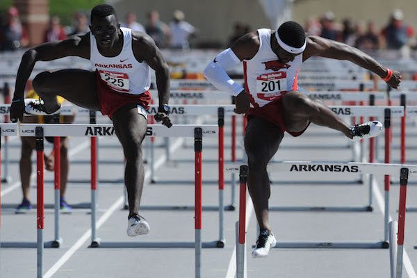 Arkansas' Davon Anderson (right) catches a hurdle Saturday, April 23, 2016, as Kemar Mowatt pulls ahead in the 110-meter hurdles during the John McDonnell Invitational at John McDonnell Field in Fayetteville.