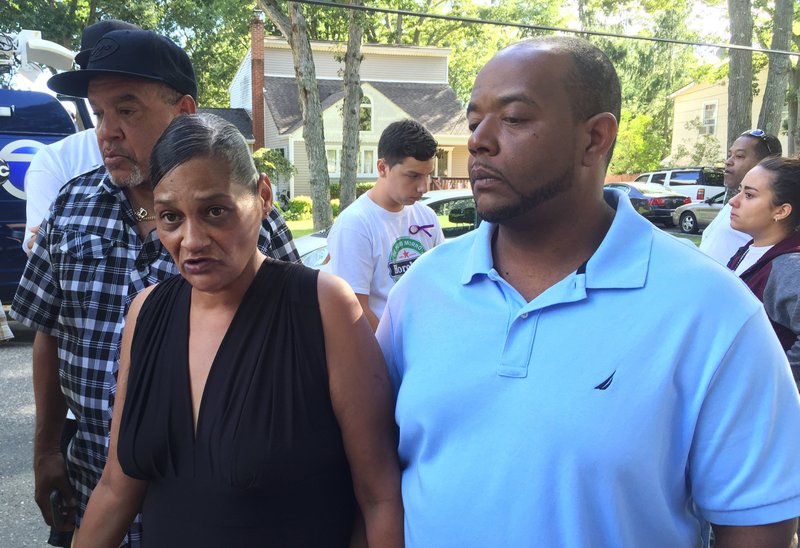 In this Sept. 15, 2016, file photo, Elizabeth Alvarado and Robert Mickens speak with members of the media at the scene where their daughter, Nisa Mickens, was found dead in Brentwood, N.Y. Authorities said Nisa was killed by the MS-13 gang. Now Robert Mickens is channeling his grief into politics with a May 16, 2017, run for his local school board.