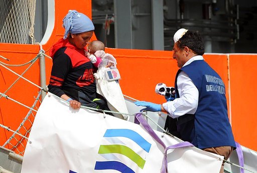 A woman carrying a baby disembarks from the Norwegian ship Siem Pilot, at the Salerno harbor, southern Italy, on Tuesday, May 9, 2017. 