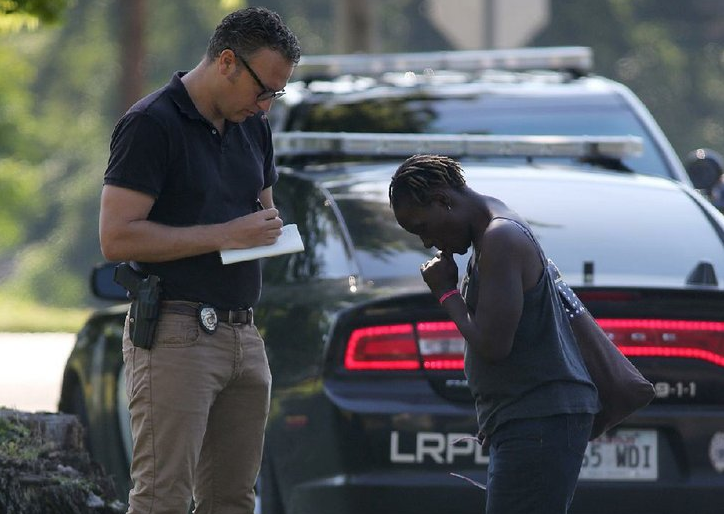 A Little Rock police detective interviews a woman Monday at the scene of a homicide at West 25th and South Arch streets.
