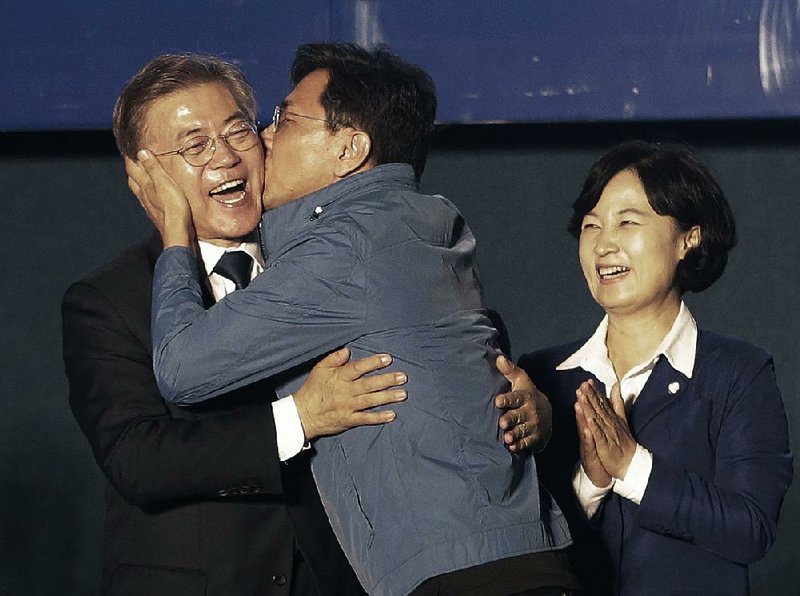 South Korean President-elect Moon Jae-in gets a congratulatory kiss from An Hee-jung, governor of South Chungcheong province, as he takes the stage today in Seoul for a victory speech. 